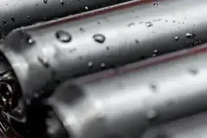 Close-up of cylindrical lithium battery cells with water droplets
